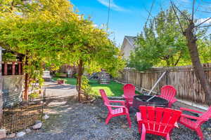 Fenced backyard featuring a fire pit and a playground