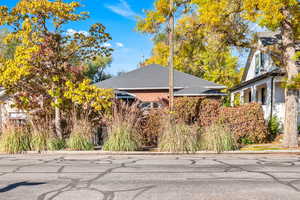 View of side of home with brick siding and roof with shingles