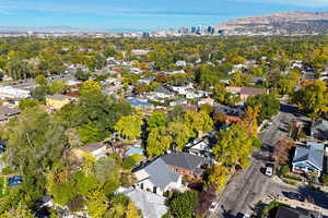 Aerial view of property and surrounding area featuring mountains, nearby suburban area, and skyline