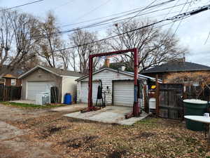 View of front facade featuring a garage and an outdoor structure