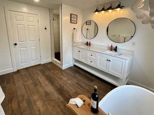 Bathroom featuring double vanity, a freestanding tub, separate toilet and a shower stall