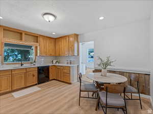 Kitchen with open shelves, dishwasher, backsplash, light wood-style floors, and recessed lighting