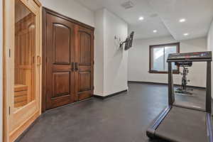 Workout area featuring concrete flooring, recessed lighting, and a relaxing sauna