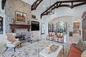Living area with high vaulted ceiling, built in shelves, a fireplace, recessed lighting, and a chandelier