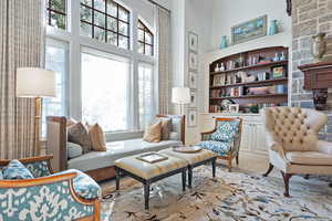 Sitting room featuring a high ceiling and built in shelves