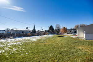 Yard covered in snow with a fenced backyard and a residential view