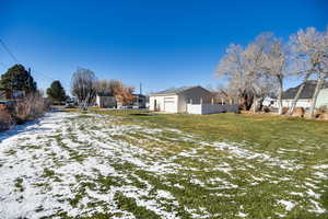Snowy yard featuring a residential view and a garage