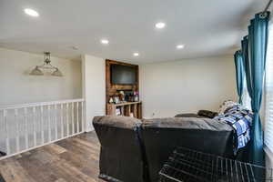 Living room with dark wood-style floors and recessed lighting