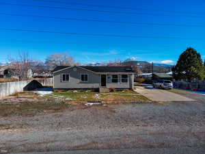 View of front of property featuring a mountain view and driveway
