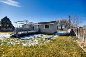 Back of property with a wooden deck and a fenced backyard