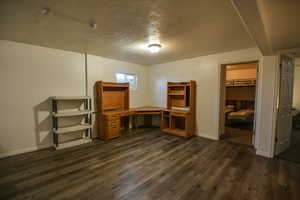 Unfurnished office with a textured ceiling and dark wood-style floors
