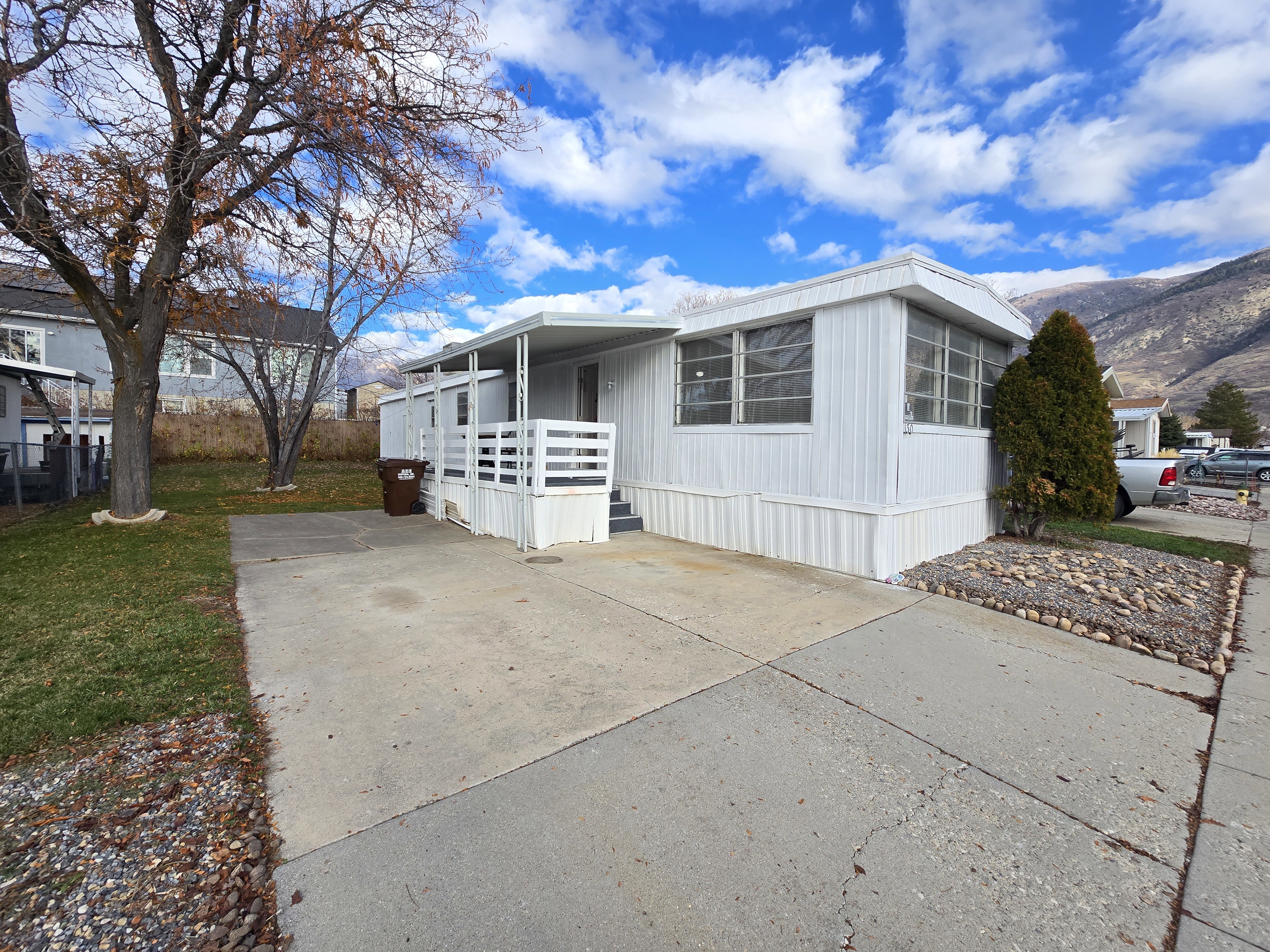 Manufactured / mobile home with a front yard and concrete driveway