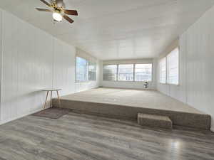 Unfurnished sunroom featuring wooden walls and wood finished floors