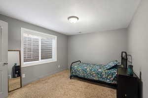 Carpeted bedroom with baseboards and a textured ceiling