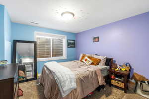 Carpeted bedroom with a textured ceiling