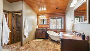 Ensuite Primary Bathroom, two vanities, a freestanding tub, and vaulted ceiling