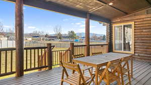 Backyard Wooden deck with outdoor dining area, a residential view, and a mountain view.  The mountains appear MUCH further away in the photos than in person.