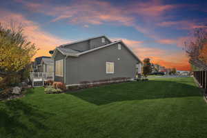 View of side of home with stucco siding and a yard