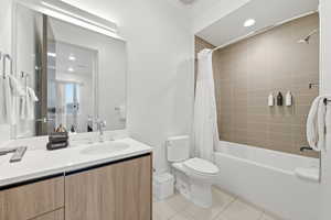 Full bath featuring vanity, shower / bath combo, light tile patterned floors, and recessed lighting