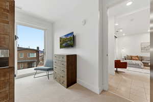 Living area featuring light colored carpet, recessed lighting, and light tile patterned floors