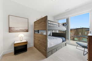 Carpeted bedroom featuring access to outside and baseboards
