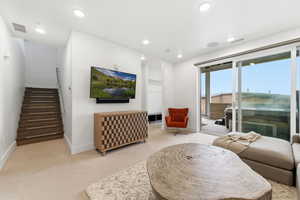 Carpeted living room with stairway and recessed lighting