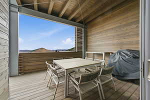 Deck featuring outdoor dining space, grilling area, and a mountain view
