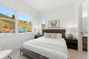 Bedroom featuring ensuite bathroom and light colored carpet