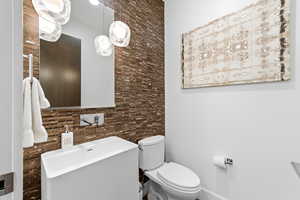 Half bathroom with vanity and tile walls