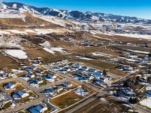 Snowy aerial view featuring a mountain view and a residential view