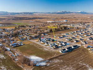 Aerial view of property's location featuring mountains, rural landscape, and nearby suburban area