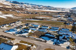Snowy aerial view featuring a mountain view and a residential view