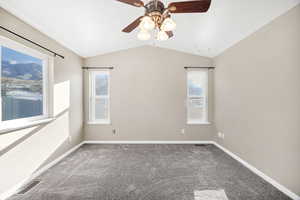 Carpeted bedroom featuring lofted ceiling, plenty of natural light, and a ceiling fan