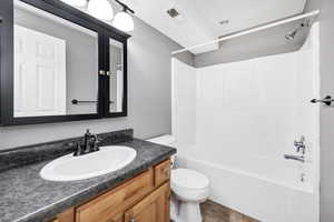 Full bath featuring shower / bath combination, vanity, and dark tile patterned flooring