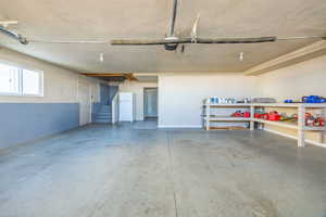 Garage with freestanding refrigerator and baseboards