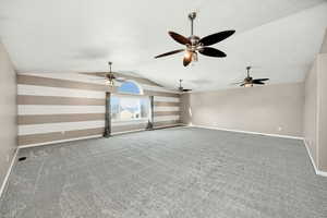 Carpeted family room featuring lofted ceiling and baseboards