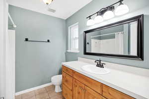 Bathroom with vanity, a shower with curtain, and light tile patterned floors