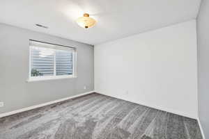 Empty bedroom featuring carpet and baseboards