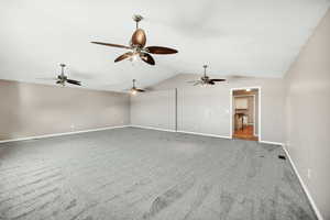 Unfurnished family room with vaulted ceiling and carpet floors