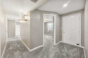 Corridor featuring carpet floors and a textured ceiling