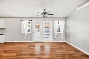 Unfurnished living room featuring light wood finished floors, vaulted ceiling, and a ceiling fan