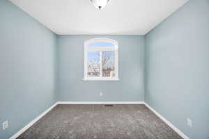 Empty bedroom with carpet floors and baseboards