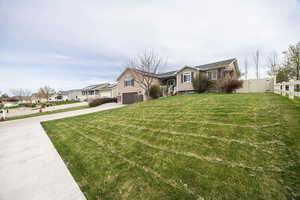 View of front of home with concrete driveway, an attached garage, and a residential view