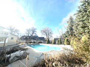 View of swimming pool with a fenced backyard and a patio