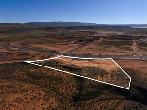 Aerial view of sparsely populated area with mountains and property parcel outlined