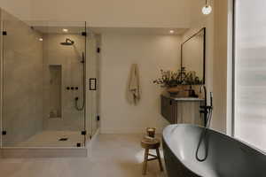 Full bath with vanity, a soaking tub, a shower stall, light tile patterned flooring, and recessed lighting