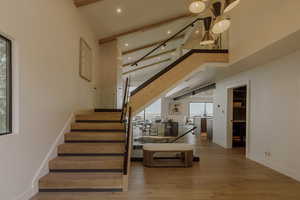 Stairway with wood finished floors and beam ceiling
