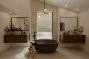 Full bathroom with lofted ceiling, a freestanding bath, recessed lighting, two vanities, and light tile patterned flooring