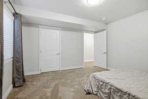 Bedroom with light carpet and baseboards