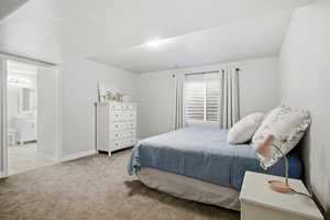 Bedroom featuring light carpet and connected bathroom
